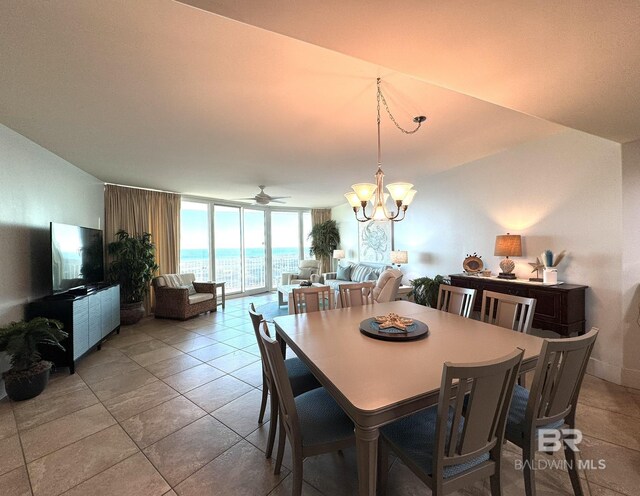 dining area featuring expansive windows and ceiling fan with notable chandelier