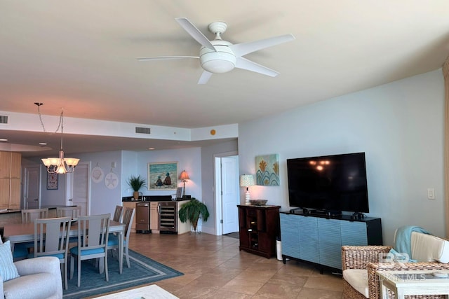 living room with wine cooler, visible vents, and ceiling fan with notable chandelier