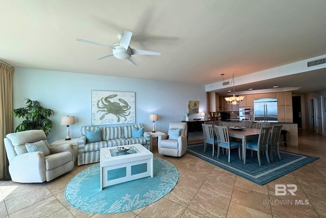 living area with visible vents and ceiling fan with notable chandelier