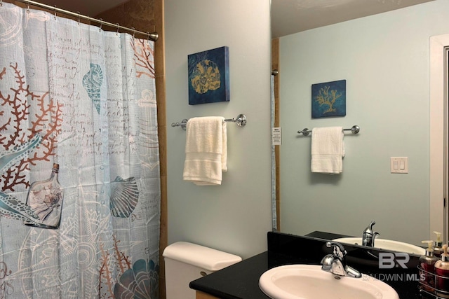 bathroom featuring toilet, curtained shower, and vanity