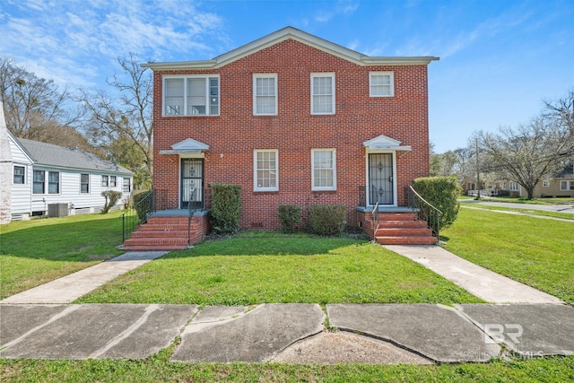 view of front of home with brick siding, central AC, and a front yard