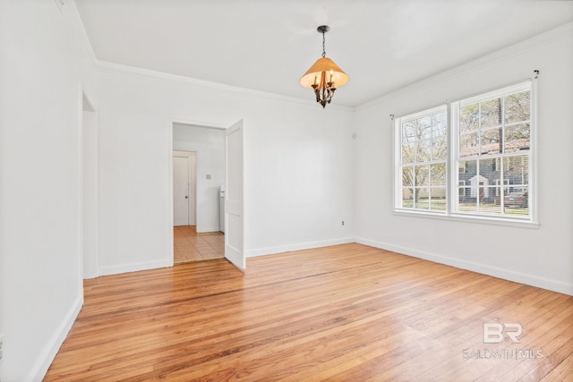 empty room with ornamental molding and light wood finished floors