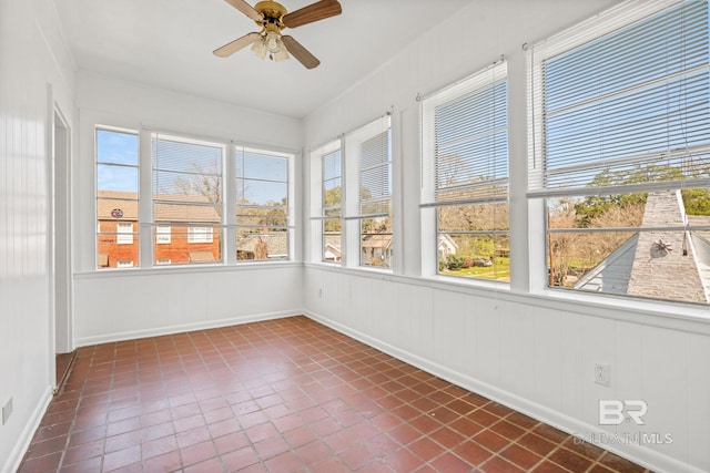 unfurnished sunroom featuring a healthy amount of sunlight and a ceiling fan