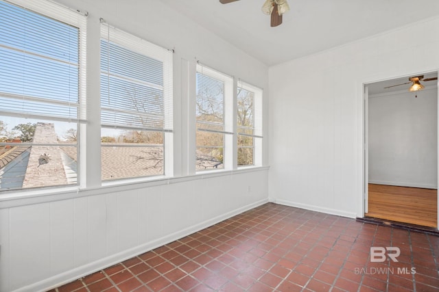 unfurnished sunroom featuring a ceiling fan