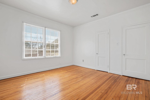 unfurnished bedroom with baseboards, wood-type flooring, visible vents, and crown molding