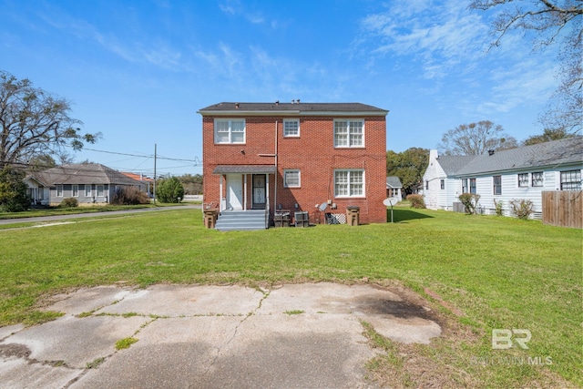 back of property with brick siding and a lawn