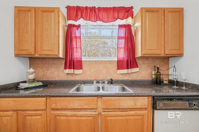 kitchen featuring dishwasher, dark countertops, decorative backsplash, and a sink