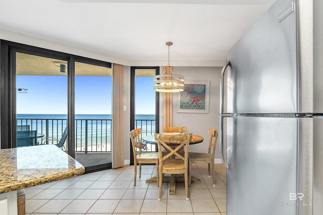 24230 Perdido Beach Blvd Unit 3077, Orange Beach, AL 36561 - dining space with a chandelier, a water view, baseboards, and light tile patterned flooring