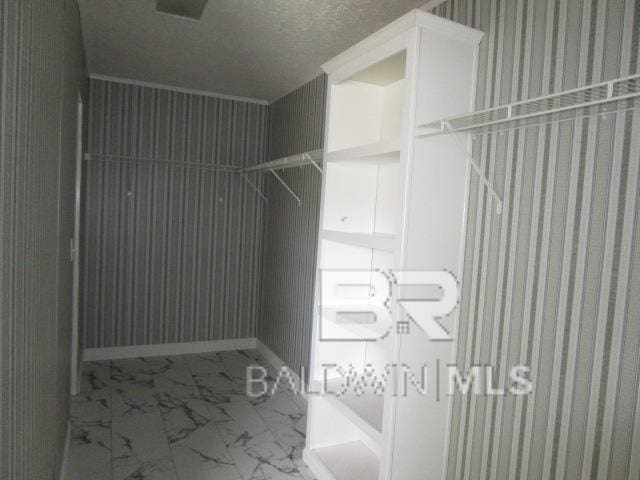 spacious closet with marble finish floor