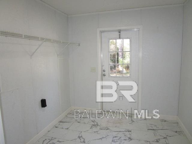 laundry area with marble finish floor and baseboards