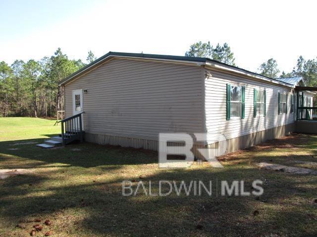 view of side of property with entry steps and a yard