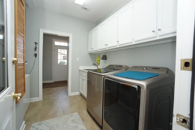 clothes washing area with cabinets, light tile patterned floors, separate washer and dryer, and sink