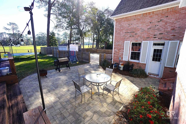 view of patio with an outdoor structure and a trampoline