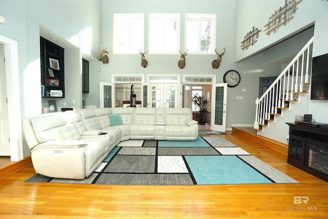 living room featuring hardwood / wood-style floors, a high ceiling, and french doors