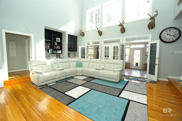 living room featuring hardwood / wood-style floors, a high ceiling, and french doors