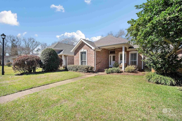 view of front facade featuring roof with shingles, brick siding, and a front lawn