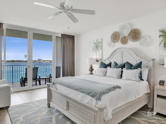 28105 Perdido Beach Blvd Unit C504, Orange Beach, AL 36561 - bedroom with a water view, access to exterior, a wall of windows, a ceiling fan, and wood finished floors
