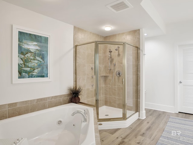 28105 Perdido Beach Blvd Unit C504, Orange Beach, AL 36561 - bathroom featuring a whirlpool tub, wood finished floors, visible vents, and a stall shower