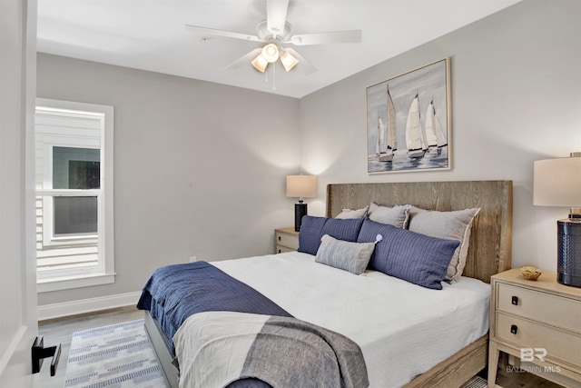 bedroom featuring baseboards, wood finished floors, and ceiling fan