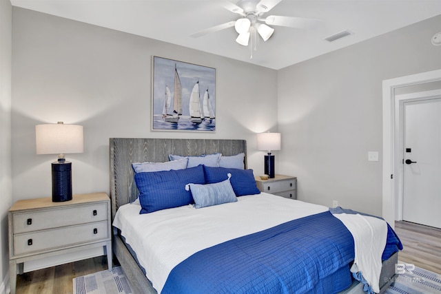 bedroom featuring visible vents, a ceiling fan, and wood finished floors