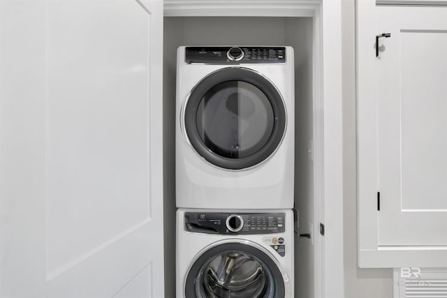 clothes washing area featuring stacked washer / drying machine and laundry area
