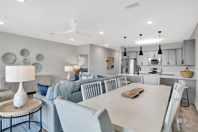dining area with light wood-style flooring, visible vents, recessed lighting, and a ceiling fan