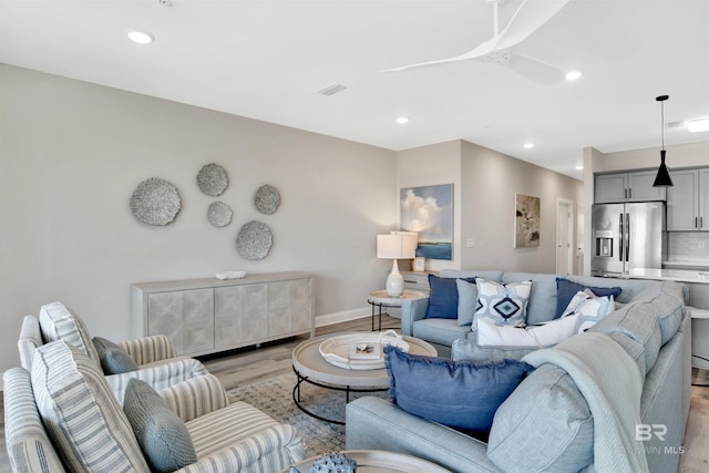 living room featuring recessed lighting, baseboards, visible vents, and light wood-type flooring