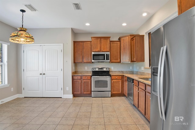 kitchen with stainless steel appliances, backsplash, pendant lighting, light tile patterned floors, and light stone counters