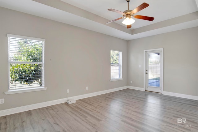 spare room with light hardwood / wood-style flooring, a wealth of natural light, and ceiling fan