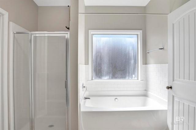 bathroom featuring a healthy amount of sunlight and shower with separate bathtub