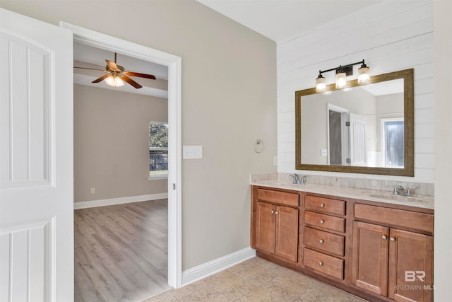 bathroom with vanity, wooden walls, wood-type flooring, and ceiling fan