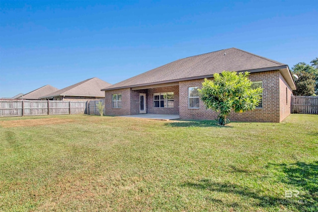 rear view of property featuring a patio area and a lawn