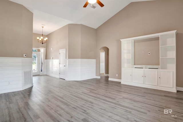 unfurnished living room featuring high vaulted ceiling, wood-type flooring, and ceiling fan with notable chandelier