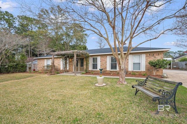 ranch-style house with a front yard and brick siding