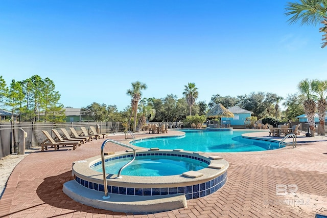 view of swimming pool featuring a community hot tub and a patio