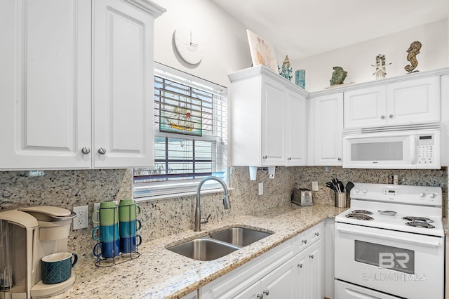 kitchen with sink, white cabinetry, light stone counters, white appliances, and decorative backsplash