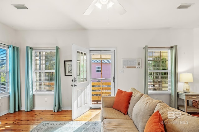 living room featuring ceiling fan, a healthy amount of sunlight, and light wood-type flooring