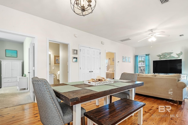 dining space featuring ceiling fan with notable chandelier and hardwood / wood-style floors