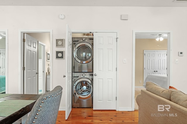 washroom with stacked washer and dryer and hardwood / wood-style floors