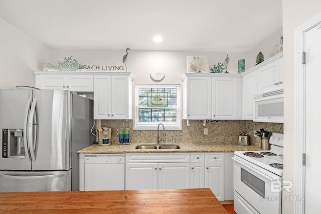 kitchen with white cabinetry, white appliances, sink, and backsplash