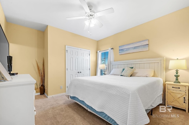 carpeted bedroom with ceiling fan and a closet