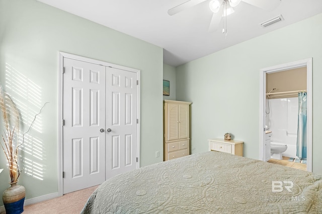 carpeted bedroom featuring ensuite bath, a closet, and ceiling fan