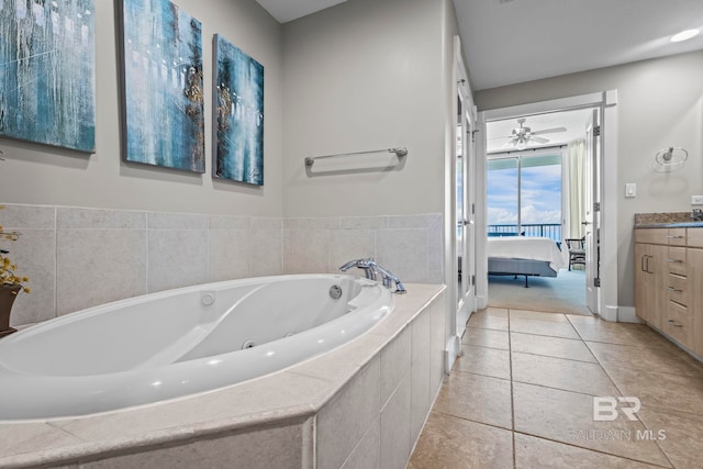 521 W Beach Blvd Unit 1702, Gulf Shores, AL 36542 - bathroom with vanity, a tub with jets, connected bathroom, tile patterned flooring, and a ceiling fan
