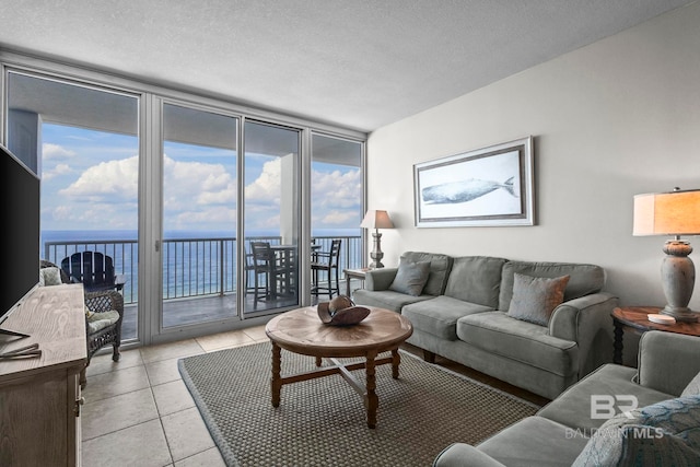 521 W Beach Blvd Unit 1702, Gulf Shores, AL 36542 - living room with a wall of windows, a water view, healthy amount of natural light, light tile patterned flooring, and a textured ceiling