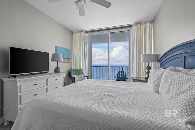 521 W Beach Blvd Unit 1702, Gulf Shores, AL 36542 - bedroom with access to exterior, a ceiling fan, a textured ceiling, and a water view