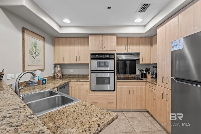 521 W Beach Blvd Unit 1702, Gulf Shores, AL 36542 - kitchen with appliances with stainless steel finishes, light brown cabinetry, under cabinet range hood, light tile patterned flooring, and a tray ceiling