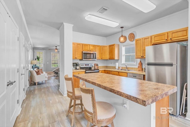 25806 Pollard Rd Unit 204, Daphne, AL 36526 - kitchen featuring stainless steel appliances, light wood-style flooring, a breakfast bar area, pendant lighting, and a center island