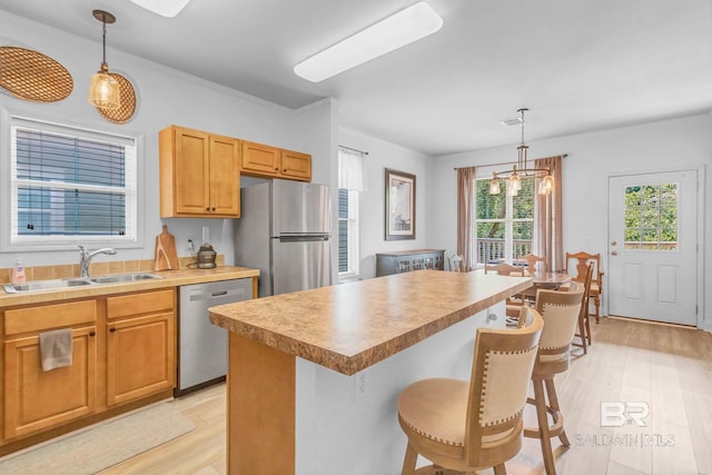 25806 Pollard Rd Unit 204, Daphne, AL 36526 - kitchen featuring stainless steel appliances, a breakfast bar, light wood-style flooring, and hanging light fixtures