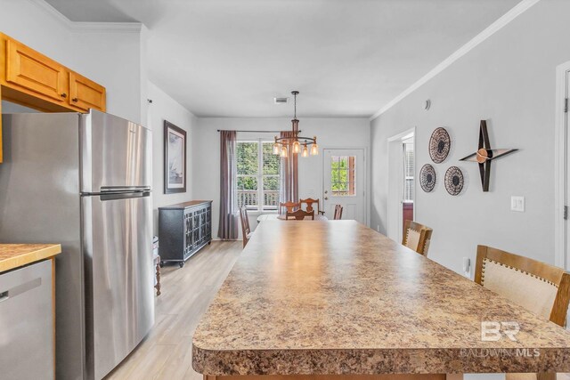 25806 Pollard Rd Unit 204, Daphne, AL 36526 - dining room featuring a chandelier, light wood-style floors, and crown molding