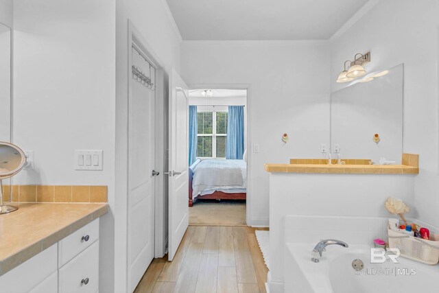 25806 Pollard Rd Unit 204, Daphne, AL 36526 - ensuite bathroom featuring wood finished floors, a bath, and ornamental molding